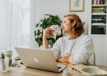 Žena drží v ruce bankovky