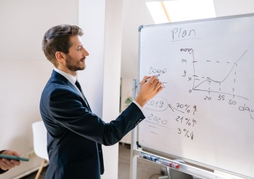 Muž píše na tabuli