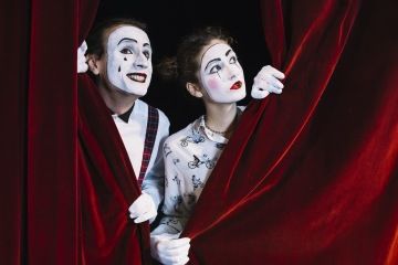 Dva klauni vykukující z opony