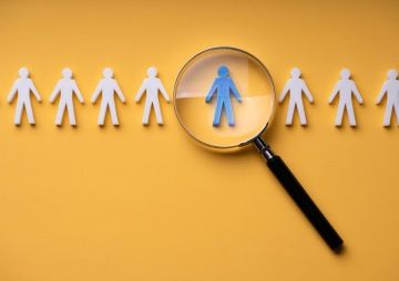 Skupina mladých lidí kouká na telefon.