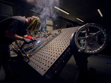 Jaroslav Moravec stojí před stavebními stroji značky Liebherr